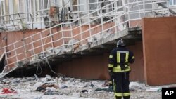 Mzima moto akisimama karibu na jengo la ghorofa lililoharibiwa na makombora ya Russia mjini Odesa, Ukraine, April 23, 2022. Picha ya AP