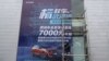 资料照：2020年8月9日，工人们在中国湖北省武汉市的一家经销店张贴了政府补贴东风标致汽车的巨幅海报。（路透社）