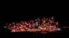 ARCHIVES - Des migrants tentent de s'accrocher à un bateau qui a chaviré au large de la Tunisie, mercredi 25 mai 2022.