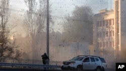Një punonjës policie shikon ndërsa droni shpërthen mbi një godinë në qendër të Kievit (17 tetor 2022)
