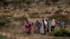 FILE - People walk from a rural area towards a nearby town where a food distribution operated by the Relief Society of Tigray was taking place, near the town of Agula, in the Tigray region of northern Ethiopia on May 8, 2021