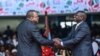 FILE - Outgoing Kenyan President Uhuru Kenyatta shakes hands with President William Ruto at the Moi International Sports Center, in Nairobi, Kenya, Sept. 13, 2022, during Ruto's inauguration.