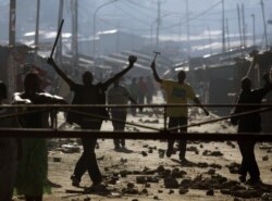 FILE - Protesters demonstrate with sticks and hammers during post-election disturbances in the Mathare slum of Nairobi, Dec. 30, 2007.