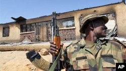 Sojan Nigeria zaune cikin mota lokacin aikin sintiri. Rundunar sojin Nigeria a Maiduguri ke binciken gida-gida domin gano makaman da 'yan tsagera suka boye.