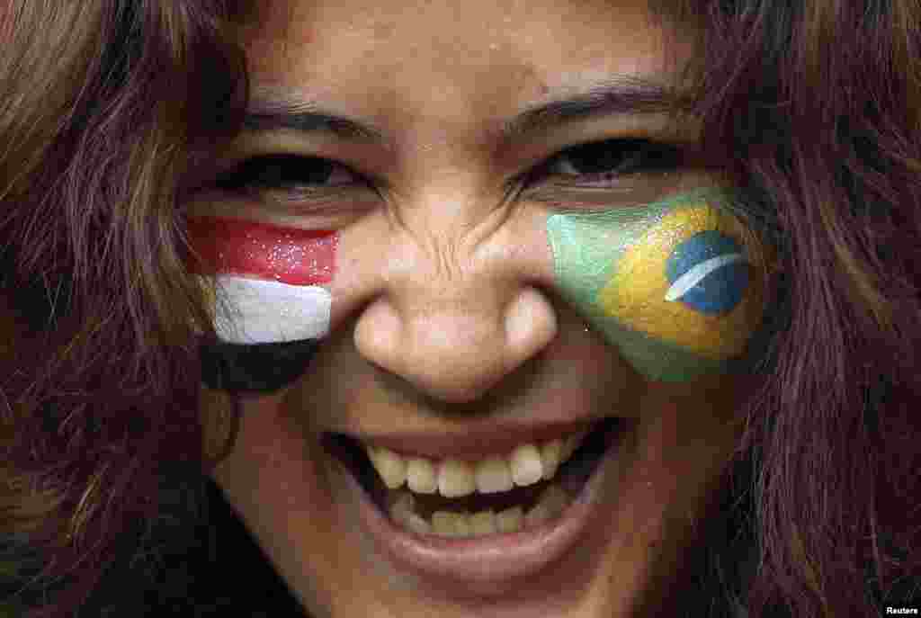A spectator with a Brazilian and an Egyptian (L) national flag on either cheek smiles ahead of the men's Group C football match between the two countries at the London 2012 Olympic Games in the Millennium Stadium in Cardiff July 26, 2012.