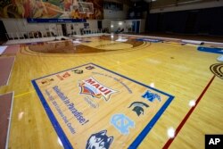 Workers set up banners and signs at Lahaina Civic Center, the venue for the Maui Invitational in Lahaina on the island of Maui in Hawaii, Nov. 18, 2024.
