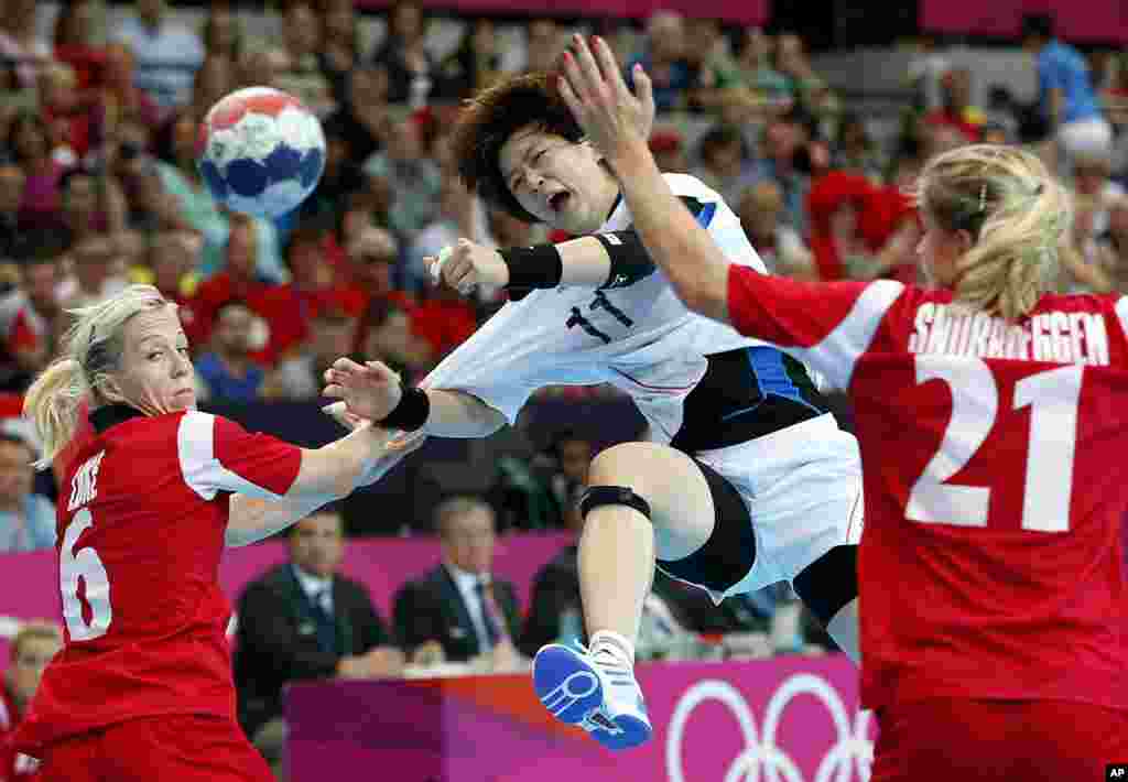 South Korea's Ryu Eun-hee, center, shoots the ball, between Norway's Goril Snorroeggen, right, and Lynn-Kristin Koren, left, during their women's handball preliminary match at the 2012 Summer Olympics, Aug. 1, 2012.