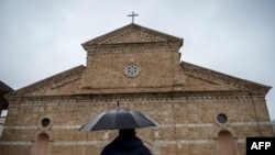 A Catholic worshipper arrives for the Easter mass held at the Roman Catholic cathedral of the Lady Helper in the town of Prizren, Southern Kosovo, on Apr. 4, 2021.