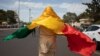 Un homme avec le drapeau national malien se joint à une manifestation de masse à Bamako, le 14 janvier 2022, pour protester contre les sanctions imposées au Mali et à la junte par la Communauté économique des États de l'Afrique de l'Ouest (CEDEAO). - (Pho