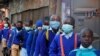 Schoolchildren queue to have their temperature checked before entering the Olympic Primary School during the reopening of schools, after the government closed learning institutions due COVID-19 outbreak, in Kibera slums of Nairobi, Jan. 4, 2021.