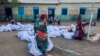 Une femme déplacée porte des sacs de l'aide humanitaire dans un camp à Gadaref, le 12 mai 2024.
