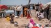 FILE - A mother of 8 children exits part of her house as her children stay around in an informal settlement of internally displaced people in the outskirts of the city of Hargeisa, Somaliland, on September 16, 2021.