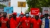Des membres du parti d'opposition National Democratic Congress (NDC) se tiennent la main lors d'une manifestation antigouvernementale dans les rues d'Accra, au Ghana, le 6 juillet 2021.