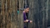ແຟ້ມ-ຜູ້ອົບພະຍົບຊາວມຽນມາຄົນນຶ່ງ ຢືນຊ່ອງເບິ່ງຈາກຝາໄມ້ໄຜ່ ຂອງຕູບຊົ່ວຄາວ ຢູ່ທີ່ສູນອົບພະຍົບແມ່ລາ, ເຊິ່ງເປັນນຶ່ງໃນທີ່ຕັ້ງຢູ່ຝັ່ງໄທ ບໍລິເວນຊາຍແດນ ໄທ-ມຽນມາ, ວັນທີ 21 ກໍລະກົດ 2014. ຊາວອົບພະຍົບ 90,000 ຄົນ ອາໄສຢູ່ 9 ສູນລຽບຊາຍແດນ ພາກັນອາໄສຢູ່ທີ່ນີ້ມາຫຼາຍທົດສະຫວັດ. 