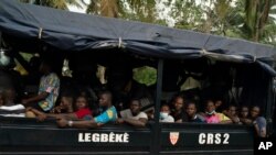 Wafuasi wa upinzani ndani ya gari la Polisi huko Abidjan, Ivory Coast, Nov. 3, 2020, wakati wa maandamano ya kupinga matokeo ya uchaguzi. 