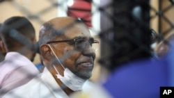 FILE - In this Sept. 15, 2020 file photo, Sudan's ousted president Omar al-Bashir sits at the defendant's cage during his trial a courthouse in Khartoum, Sudan, Sept. 15, 2020. 
