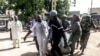 Security forces transport with a blanket the remains of some of the 11 victims of a double blast in the northern Cameroonian city of Maroua, July 22, 2015. 