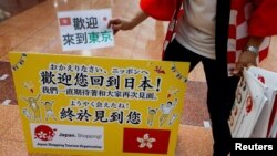 日本一家旅遊公司的員工在羽田機場歡迎一個香港旅遊團。（2022年6月26日）