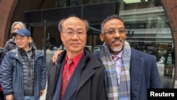 被控非法充當中國政府代理人的波士頓男子梁利堂(Litang Liang，音譯)2025年2月10日在被判無罪後和其辯護律師合影。