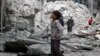 A boy inspects a damaged site after airstrikes on the rebel-held Tariq al-Bab neighbourhood of Aleppo, Syria, Sept. 23, 2016. 
