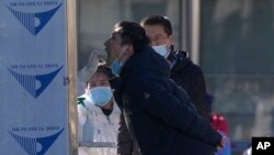 Para warga mengantri untuk menjalani tes usap COVID-19 di salah satu lokasi tes di distrik Xicheng, di Beijing, China, pada 27 Januari 2022. (Foto: AP/Andy Wong)