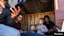 Foto ilustrasi yang menunjukkan keluarga pencari suaka asal Brazil menunggu untuk dipindahkan oleh Petugas Patroli Perbatasan AS setelah menyeberangi perbatasan dari Meksiko menuju Jacumba Hot Springs, California, pada 29 April 2024. (Foto: Reuters/Go Nakamura)
