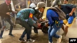 စစ်အာဏာသိမ်းမှုဆန့်ကျင်ကန့်ကွက်မှု လုံခြုံရေးတပ်ဖွဲ့ရဲ့အကြမ်းဖက်ဖြိုခွဲစဉ် ဦးခေါင်းဒဏ်ရာရသူတဦးအား သယ်ဆောင်လာကြစဉ်။ (ဧပြီ ၃၊ ၂၀၂၁/AFP) 
