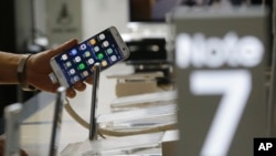 Seorang konsumen memegang smartphone Samsung Galaxy Note 7 di markas operator ponsel Korea Selatan, KT, di Seoul, Korea Selatan (foto: dok). 