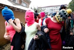 Các thành viên che mặt của nhóm nhạc bất đồng chính kiến Pussy Riot rời sở cảnh sát Adler trong thời gian diễn ra Thế vận hội mùa đông 2014 ở Sochi hôm 18/2/2014.