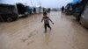 An internally displaced Syrian boy walks through the Bab Al-Salam refugee camp, near the Syrian-Turkish border, northern Aleppo province, Syria, Dec. 26, 2016.