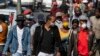 Des piétons portant des masques faciaux pour se protéger du coronavirus marchent dans la rue au centre-ville de Johannesburg, en Afrique du Sud, le 11 mai 2020. (Photo AP)