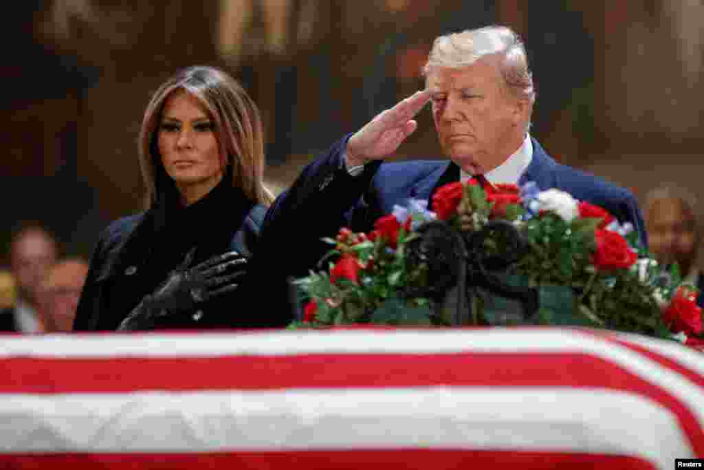 Rais wa Marekani Donald J. Trump, akiwa na mkewe wake Melania Trump, akipiga saluti kuonyesha heshima kwa mwili wa Rais wa zamani wa Marekani George H.W. Bush katika chumba cha Rotunda kilichoko katika Bunge la Marekani Washington, DC, Desemba 3, 2018 