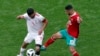 L'Iranien Masoud Shojaei et le Marocain Younes Belhanda lors du match du groupe B entre le Maroc et l'Iran à la Coupe du monde de football 2018 à Saint-Pétersbourg, Russie, le 15 juillet 2018.