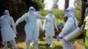 FILE - Health workers wearing protective suits prepare to bury coronavirus victim Dr. Doreen Adisa Lugaliki, at her funeral in Ndalu, Bungoma county, Kenya, July 13, 2020.