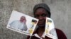 Une femme pose avec des drapeaux à l’effigie du pape François devant une église catholique à Maputo, Mozambique, le 31 août 2019.
