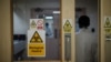FILE - An employee walks through a door at a hospital in Nairobi, Kenya, April 24, 2020. Security is being increased at children's homes and hospitals in Kenya after three medical officers were charged Nov. 18, 2020, with child trafficking. 