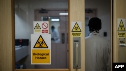 FILE - An employee walks through a door at a hospital in Nairobi, Kenya, April 24, 2020. Security is being increased at children's homes and hospitals in Kenya after three medical officers were charged Nov. 18, 2020, with child trafficking. 