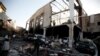 FILE - People stand at the site of an airstrike on a hall where a wake was being held in Sana'a, Yemen, Oct. 8, 2016.