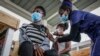 FILE - A nurse gives a shot of AstraZeneca coronavirus vaccine, donated by Denmark, to a woman at Mbagathi Hospital in Nairobi, Kenya, July 9, 2021. 